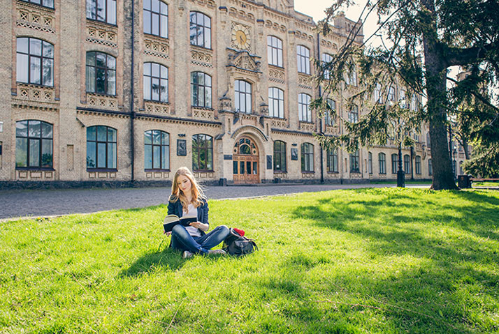 student reading outside campus